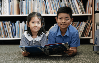 A photo of two St Martha's Catholic Primary School Strathfield's students smiling in the library, and on the journey to 2025 NAPLAN results success